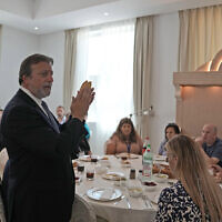 Rabbi Elie Abadie says a blessing as he hosts a lunch for a Jewish business delegation at a villa that serves as a temporary synagogue for his congregation in Dubai, United Arab Emirates, May 10, 2022. (AP Photo/Kamran Jebreili)