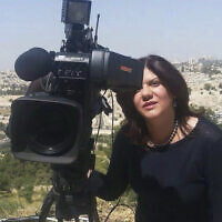 In this undated photo provided by Al Jazeera Media Network, Shireen Abu Akleh, a journalist for Al Jazeera network, stands next to a TV camera with the Old City of Jerusalem in the background. (Al Jazeera Media Network via AP)