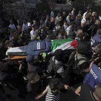 Palestinian militants carry the body of Shireen Abu Akleh, a journalist for Al Jazeera network, into the morgue inside the Hospital in the West Bank town of Jenin, May 11, 2022. (AP Photo/Majdi Mohammed)