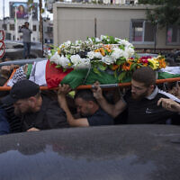 Palestinian mourners carry the body of Shireen Abu Akleh out of the office of Al Jazeera after friends and colleagues paid their respects, in the West Bank city of Ramallah, Wednesday, May 11, 2022. (AP/Nasser Nasser)