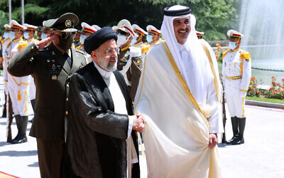 In this photo released by the official website of the office of the Iranian Presidency, Qatari Emir Sheikh Tamim bin Hamad Al Thani, right, shakes hands with President Ebrahim Raisi during an official arrival ceremony at the Saadabad Palace in Tehran, Iran, on May 12, 2022. (Iranian Presidency Office via AP)