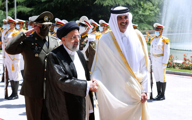 In this photo released by the official website of the office of the Iranian Presidency, Qatari Emir Sheikh Tamim bin Hamad Al Thani, right, shakes hands with President Ebrahim Raisi during an official arrival ceremony at the Saadabad Palace in Tehran, Iran, May 12, 2022. (Iranian Presidency Office via AP)