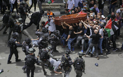 Israeli police confront mourners as they carry the casket of slain Al Jazeera veteran journalist Shireen Abu Akleh during her funeral in east Jerusalem, on May 13, 2022. (AP Photo/Maya Levin)