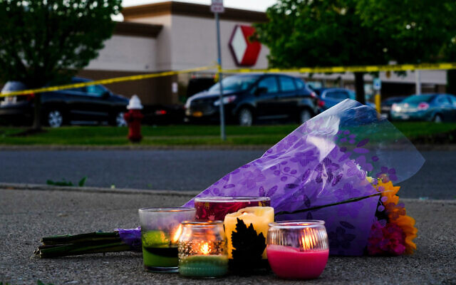 Flowers and candles lay outside the scene of a shooting at a supermarket, in Buffalo, N.Y., Sunday, May 15, 2022. (AP Photo/Matt Rourke)