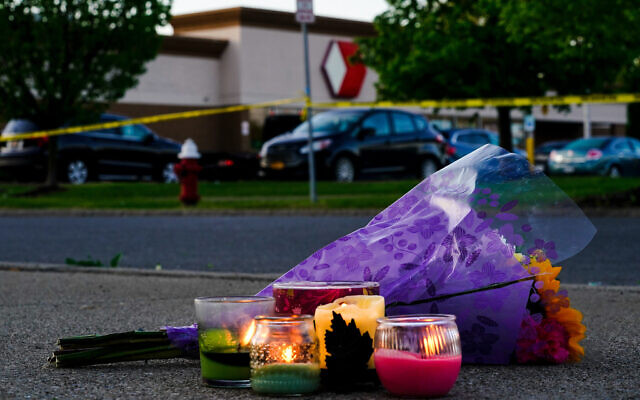 Flowers and candles outside the scene of a shooting at a supermarket, in Buffalo, NY, May 15, 2022. (AP Photo/Matt Rourke)