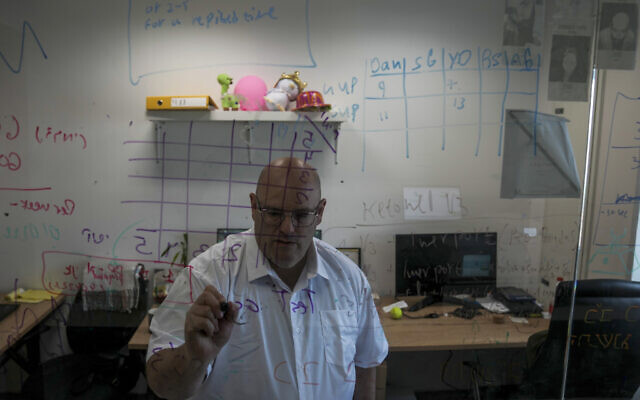 Harel Hershtik works at his lab in Rehovot, May 11, 2022. (Ariel Schalit/AP)