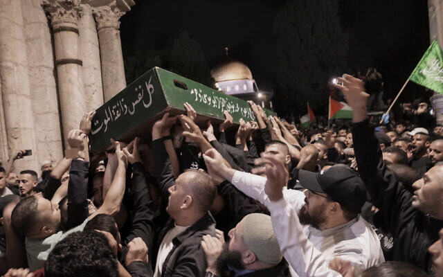 Mourners carry the coffin of Palestinian, Walid a-Sharif, 21, during his funeral at the Al Aqsa Mosque compound on the Temple Mount in Jerusalem's Old City, Monday, May 16, 2022. (AP Photo/Mahmoud Illean)