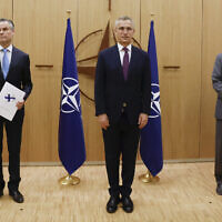 Finland's Ambassador to NATO Klaus Korhonen, left, NATO Secretary-General Jens Stoltenberg and Sweden's Ambassador to NATO Axel Wernhoff attend a ceremony to mark Sweden's and Finland's application for membership in Brussels, Belgium, May 18, 2022. (Johanna Geron/Pool via AP)