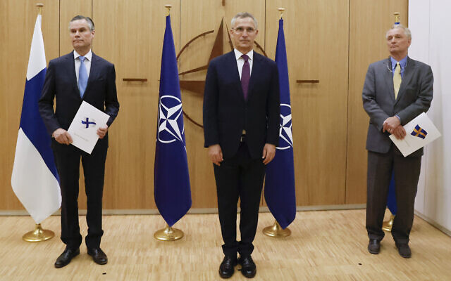 Finland's Ambassador to NATO Klaus Korhonen, left, NATO Secretary-General Jens Stoltenberg and Sweden's Ambassador to NATO Axel Wernhoff attend a ceremony to mark Sweden's and Finland's application for membership in Brussels, Belgium, May 18, 2022. (Johanna Geron/Pool via AP)