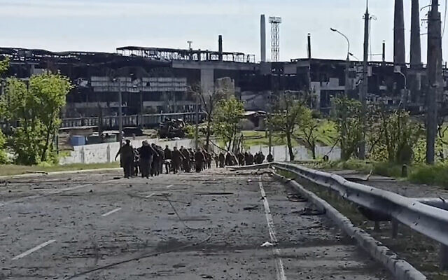 In this photo taken from video released by the Russian Defense Ministry Press Service on May 18, 2022, Ukrainian servicemen leave the besieged Azovstal steel plant in Mariupol, Ukraine. (Russian Defense Ministry Press Service via AP)