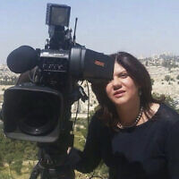 In this undated photo provided by Al Jazeera Media Network, reporter Shireen Abu Akleh stands next to a TV camera above the Old City of Jerusalem. (Al Jazeera Media Network via AP)