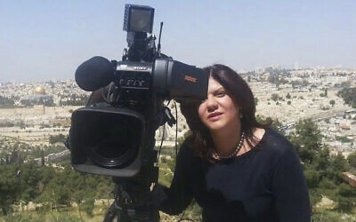 Shireen Abu Akleh stands next to a TV camera above the Old City of Jerusalem, in an undated photo. (Al Jazeera Media Network via AP)