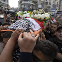 Palestinian mourners carry the body of veteran Palestinian-American reporter Shireen Abu Akleh out of the office of Al Jazeera after friends and colleagues paid their respects, in the West Bank city of Ramallah, May 11, 2022. (AP/Nasser Nasser, File)