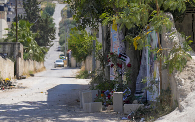 Flowers, flags and other memorabilia create a makeshift memorial at the site where veteran Palestinian-American reporter Shireen Abu Akleh was shot and killed, in the West Bank city of Jenin, May 19, 2022. (AP/Majdi Mohammed)
