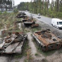 Cars pass by destroyed Russian tanks in a recent battle against Ukrainians in the village of Dmytrivka, close to Kyiv, Ukraine, May 23, 2022. Three months after it invaded Ukraine hoping to overtake the country in a blitz, Russia has bogged down in what increasingly looks like a war of attrition with no end in sight. (AP Photo/Efrem Lukatsky, File)