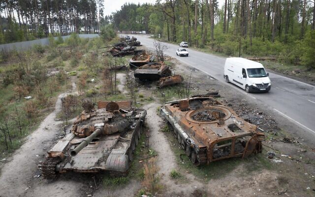 Cars pass by destroyed Russian tanks in a recent battle against Ukrainians in the village of Dmytrivka, close to Kyiv, Ukraine, May 23, 2022. (AP Photo/Efrem Lukatsky, File)