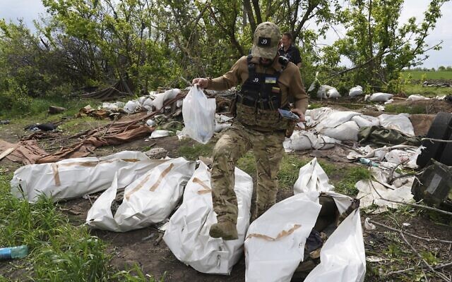 A Ukrainian serviceman works during the exhumation of killed Russian soldiers' at their former positions near the village of Malaya Rohan, on the outskirts of Kharkiv, Ukraine, May 18, 2022. (AP Photo/Andrii Marienko, file)