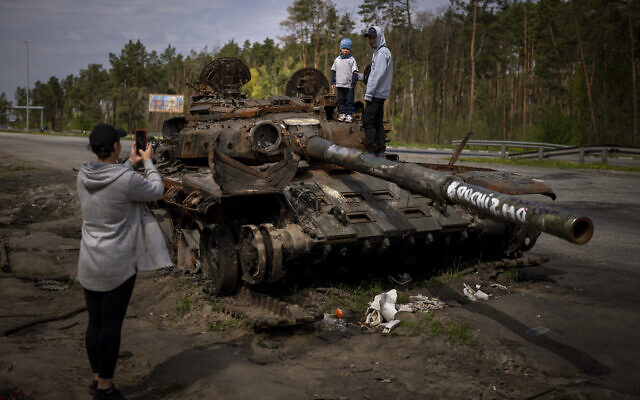 Maksym, 3, is photographed with his brother, Dmytro, 16, on top of a destroyed Russian tank, on the outskirts of Kyiv, Ukraine, May 8, 2022. (AP Photo/Emilio Morenatti, File)