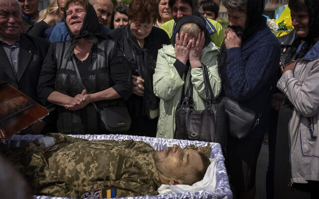 Relatives react next to the body of Oleksandr Pankratov, 49, a Ukrainian military serviceman who was killed in Donetsk province, during his funeral in Lviv, Ukraine, May 14, 2022. (AP Photo/Emilio Morenatti, file)