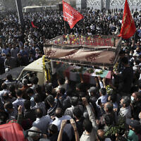 Mourners gather around a truck carrying the flag draped coffin of Iran's Revolutionary Guard Col. Hassan Sayyad Khodaei who was killed on Sunday, in his funeral ceremony in Tehran, Iran, Tuesday, May 24, 2022. (AP/Vahid Salemi)