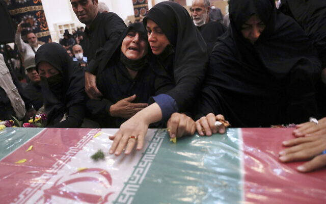 Relatives mourn over the flag draped coffin of Iran's Revolutionary Guard Col. Hassan Sayyad Khodaei during his funeral ceremony in Tehran, Iran, May 24, 2022. (AP Photo/Vahid Salemi)