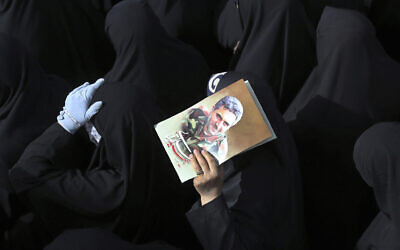 Mourners attend the funeral ceremony of Iran's Revolutionary Guard Col. Hassan Sayyad Khodaei, shown in the poster, who was killed on Sunday, in Tehran, Iran, Tuesday, May 24, 2022.  (AP Photo/Vahid Salemi)