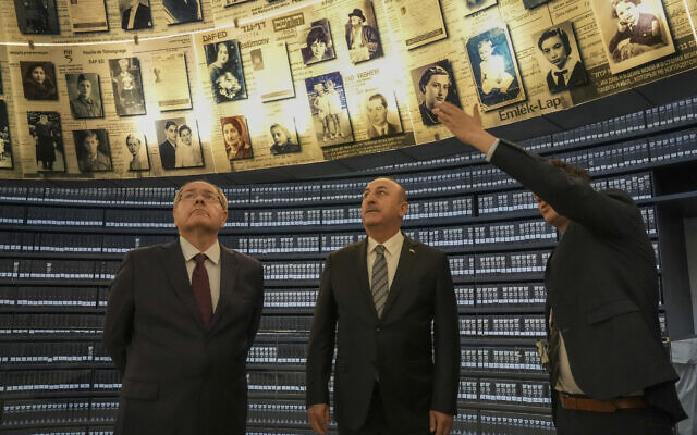 Turkish Foreign Minister Mevlut Cavusoglu, center, visits with Dani Dayan, Yad vashem chairman, left, at the Hall of Names in the Yad Vashem World Holocaust Remembrance Center in Jerusalem, May 25, 2022. (AP Photo/ Maya Alleruzzo)