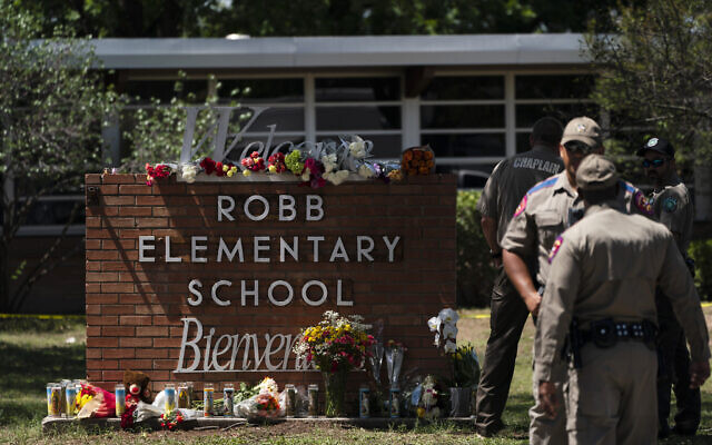 Flowers and candles are placed outside Robb Elementary School in Uvalde, Texas to honor the victims killed in Tuesday's shooting at the school. (AP Photo/Jae C. Hong)