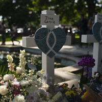 The cross at the gravesite of Irma Garcia, a teacher who was killed in this week's elementary school shooting. Her husband, Joe Garcia, died two days after the shooting. Thursday, May 26, 2022. (AP Photo/Jae C. Hong)