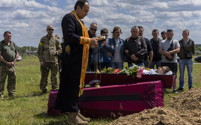 Relatives and friends attend the funeral of Ukrainian serviceman Vitaliy Nejenits in Kharkiv cemetery, eastern Ukraine, Friday, May 27, 2022. (AP Photo/Bernat Armangue)