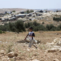 A Palestinian boy walks while backdropped by his home village of Susiya in Area C of the West Bank on July 24, 2015.  (AP/Nasser Nasser)