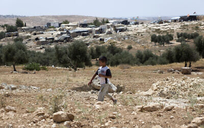 A Palestinian boy walks while backdropped by his home village of Susiya in Area C of the West Bank on July 24, 2015. (AP/Nasser Nasser)