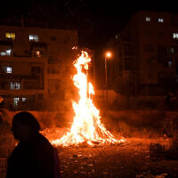 People celebrate Lag B'Omer near a bonfire, in Kiryat Sefer on May 22, 2019. (Yossi Zeliger/Flash90)