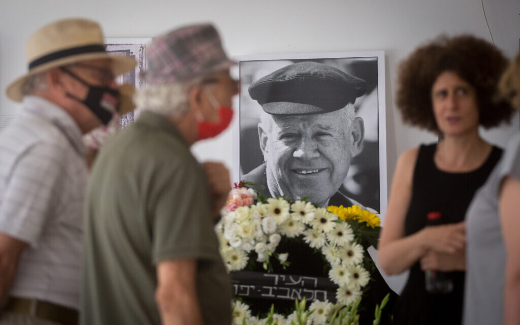 Friends and family pay their respects by the coffin holding Israeli sculptor artist Dani Karavan, who died on May 29, 2021. His eldest daughter, Noa Karavan-Cohe is standing to the right of his photo (Miriam Alster/Flash90)