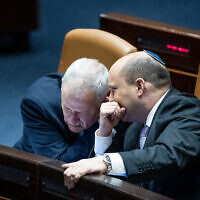 File: Prime Minister Naftali Bennett, right, with Minister of Defense Benny Gantz during a plenum session at the Knesset, on February 28, 2022. (Yonatan Sindel/Flash90)
