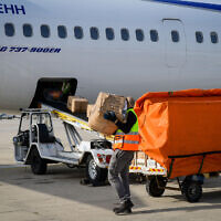 Workers load packages of Israeli humanitarian aid for Ukraine onto El Al aircraft, at Ben Gurion airport in Tel Aviv, on March 1, 2022. (Avshalom Sassoni‎‏/Flash90)