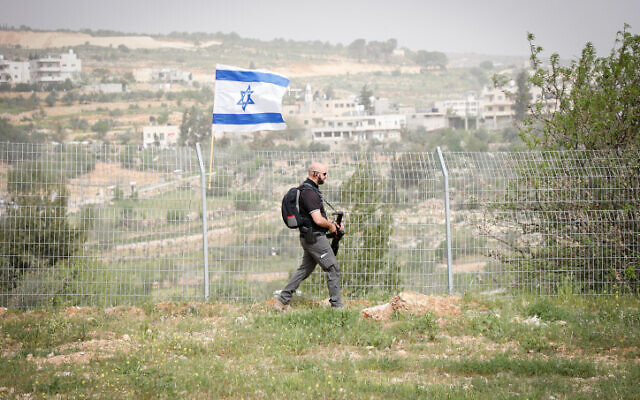 A security guard patrols the fence around the West Bank settlement of Efrat on April 8, 2022. (Gershon Elinson/FLASH90)