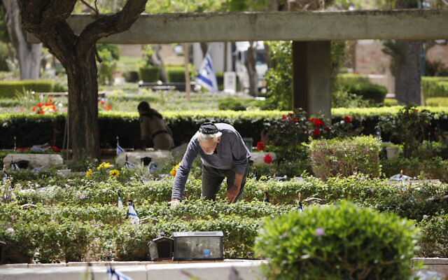A man visits a grave of a loved one at the military cemetery in Haifa, May 3, 2022. (Shir Torem/Flash90)