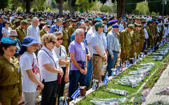 People stand still during the Memorial Day siren at Nahalat Yitzhak military cemetery in Tel Aviv on May 4, 2022. (Avshalom Sassoni/Flash90)
