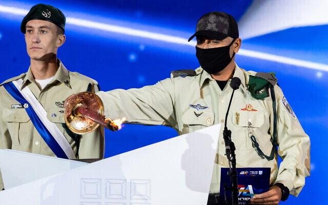 The commander of the Yamam police counter-terrorism unit lights a torch during the ceremony for Israel's 74th Independence Day at Mount Herzl in Jerusalem, on May 4, 2022. (Yonatan Sindel/Flash90)