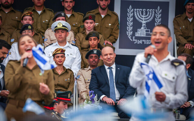 Prime Minister Naftali Bennett watches as soldiers sing during an event for outstanding soldiers as part of Israel's 74th Independence Day celebrations, at the President's Residence in Jerusalem on May 5, 2022. (Yonatan Sindel/Flash90)
