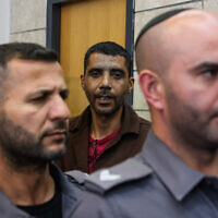 Zakaria Zubeidi (C) who escaped out of Israel's high security Gilboa prison and others, surrounded by prison guards as he arrives for a court hearing in the northern Israeli city of Nazareth, May 22, 2022 (Oren Ziv/POOL)