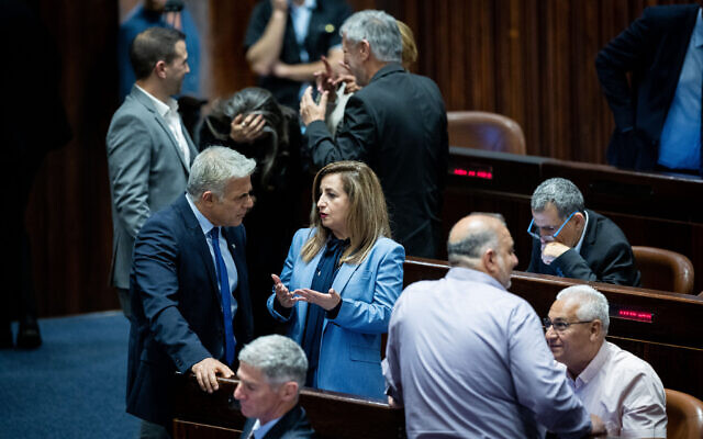 Foreign Minister Yair Lapid speaks with Meretz MK Ghaida Rinawie Zoabi during a plenum session at the Knesset on May 23, 2022. (Yonatan Sindel/Flash90)
