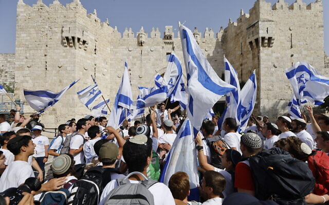 Young Jews waving Israeli flags dance at Damascus Gate to Jerusalem's Old Ciy on May 29, 2022, as Israel marks Jerusalem Day. (Olivier Fitoussi/Flash90)
