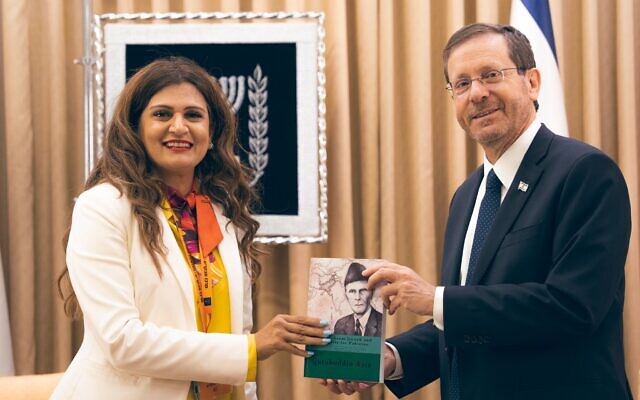 Pakistani-American Anila Ali gives a book to President Isaac Herzog during a rare trip by a Pakistani national to Israel in May. (Twitter)