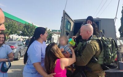 Col. Arik Moyal and other IDF soldiers return a toddler to his mother, after the car he was in was stolen from a gas station in northern Israel and taken to a West Bank town on  May 28, 2022. (Israel Defense Forces)