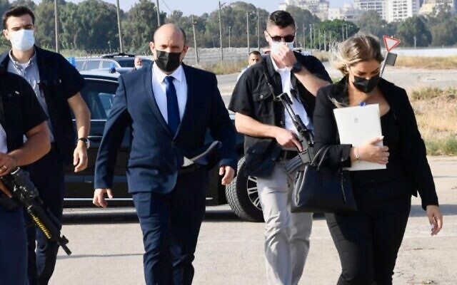Prime Minister Naftali Bennett strolls with aide Naomi Sasson (right), whose resignation was announced on May 30, 2022. (Courtesy)