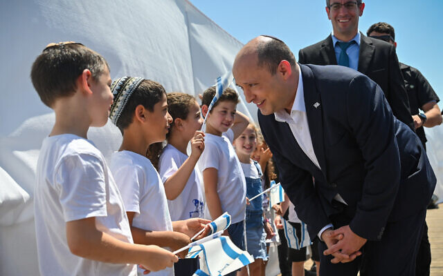 Prime Minister Naftali Bennett meets with children in the West Bank settlement of Elkana on May 17, 2022. (Kobi Gideon / GPO)
