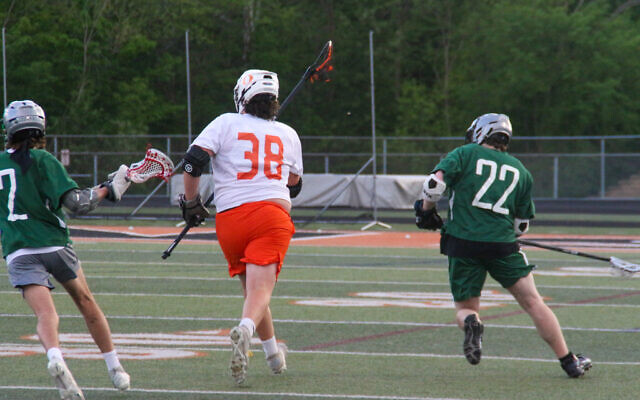 A Lake Catholic high school lacrosse player (left) is seen participating in a match May 16, 2022, with a swastika on his right calf. (Rachel Glazer)