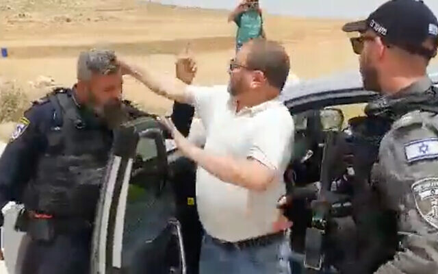 Then-Joint List Knesset member Ofer Cassif hits a police officer in the West Bank on May 13, 2022. (Screenshot)